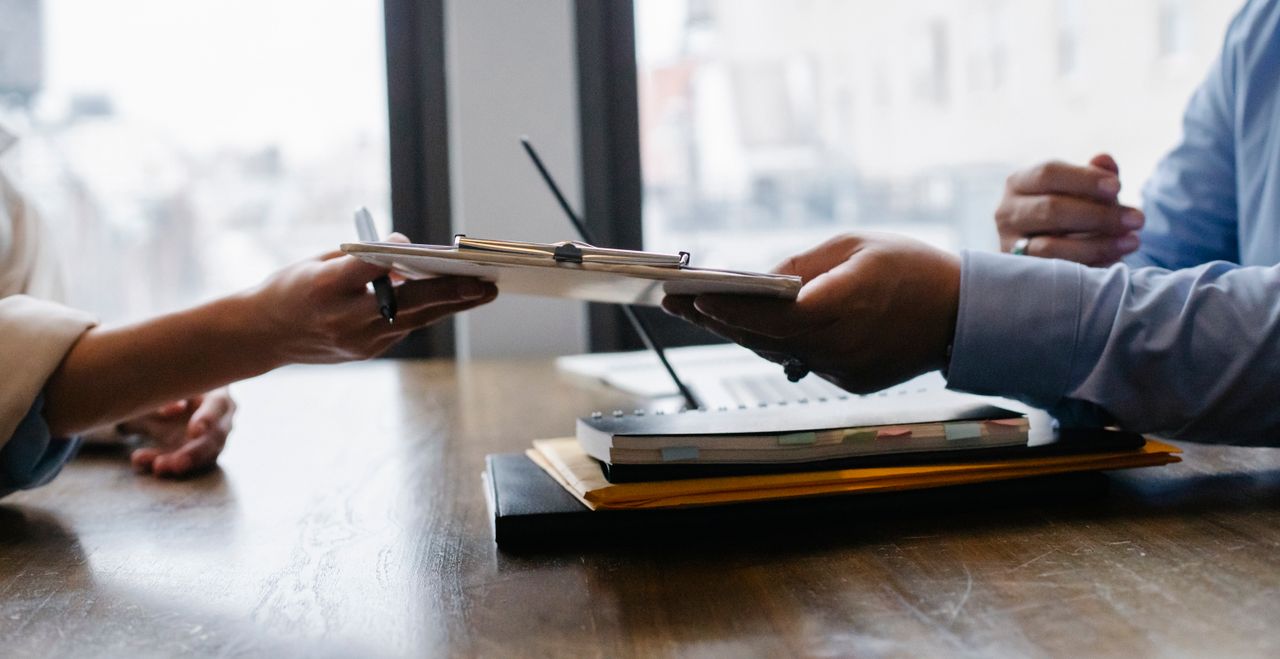 Crafting Captivating Headlines: Your awesome post title goes here Crop anonymous ethnic woman passing clipboard to office worker with laptop during job interview